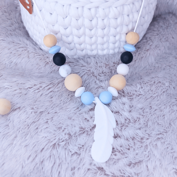 collar-porteo-silicona-pluma-azul-negro-madera-beige